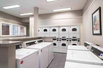 a laundromat with four rows of washers and dryers at Elme Druid Hills, Atlanta, 30329